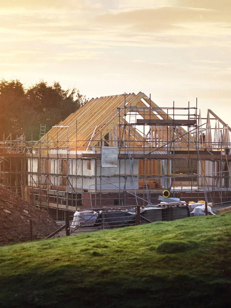 House framed with scaffolding at sunset