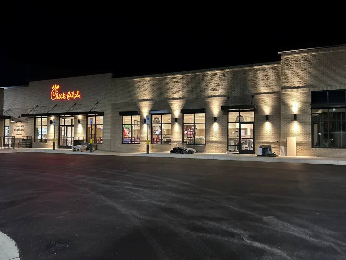 Restaurant storefront at night with wall-wash lighting