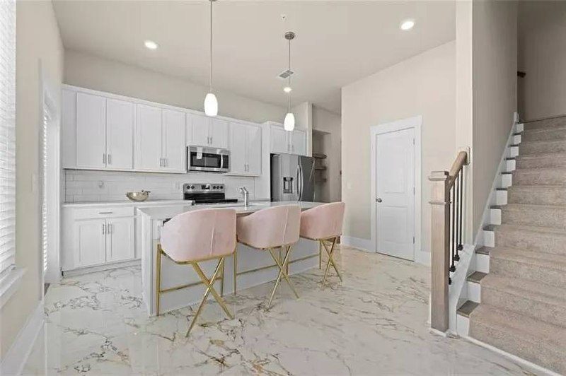 Kitchen with blush stools and marble floor